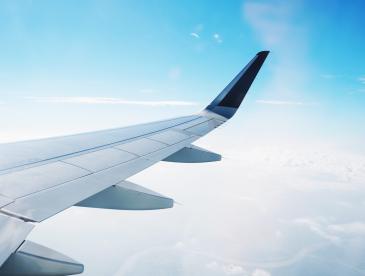 View of the wing of a plane as it flies through the clouds