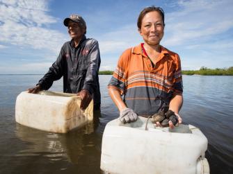 Fishers in Mexico standing in the water with their catch