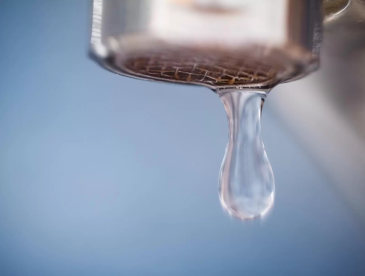 Drop of water falling from the pipe (selective focus)